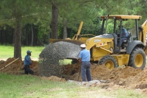 Adcock Excavating crew installing a septic system with a backhoe